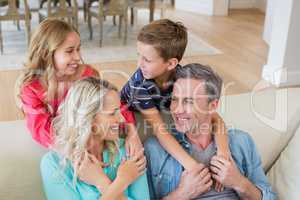 Smiling parents and kids looking face to face in living room