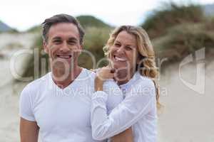 Smiling mature couple standing together on the beach