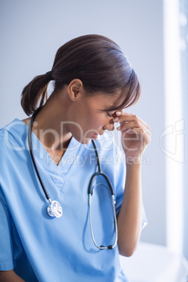 Tensed doctor sitting in corridor