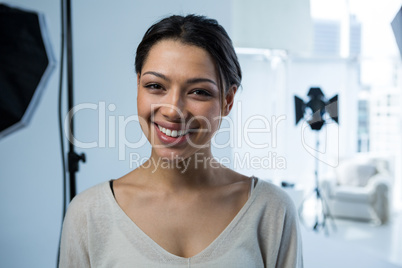 Happy female photographer standing in studio