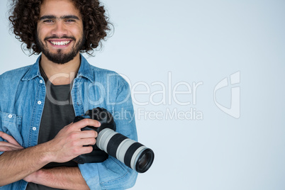 Happy male photographer standing in studio