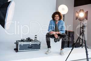 Happy male photographer sitting in studio