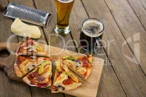 Italian pizza served on a chopping board with a beer mug and glass