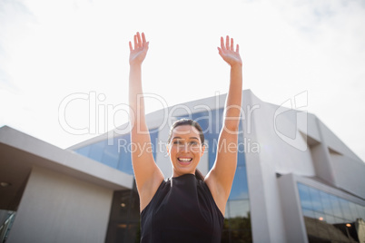 Portrait of a beautiful and happy businesswoman with arms up