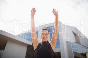 Portrait of a beautiful and happy businesswoman with arms up