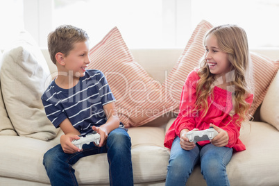 Siblings playing video games in living room