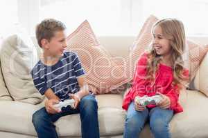 Siblings playing video games in living room
