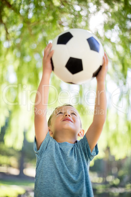Boy playing with a football in park