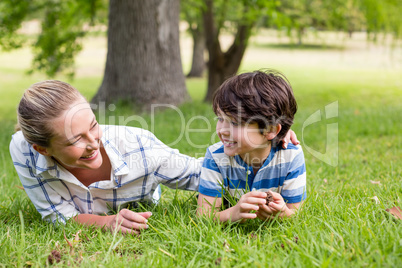 Happy mother and son lying in park