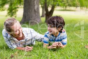 Happy mother and son lying in park