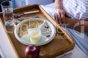 Tray with apple and medicine kept on front of patient