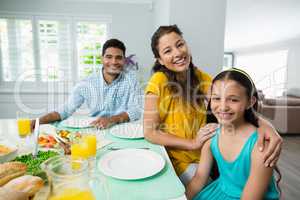 Daughter and parents having meal on table at home