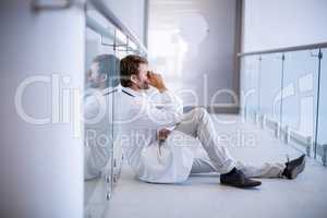 Tensed doctor sitting in corridor