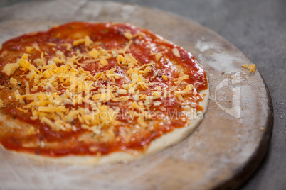 Pizza dough with tomato sauce with grated cheese