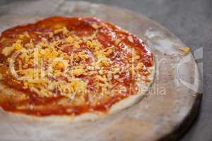 Pizza dough with tomato sauce with grated cheese