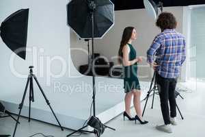 Photographer and female model reviewing captured photos in digital camera