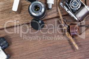 Close-up of old fashioned cameras, lens, bulb on table