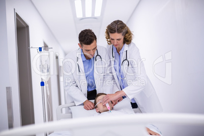 Doctors adjusting oxygen mask while rushing the patient in emergency room