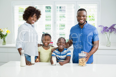 Portrait of parents and kids standing with arms around