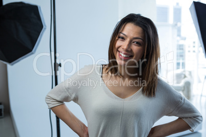 Happy female photographer standing in studio