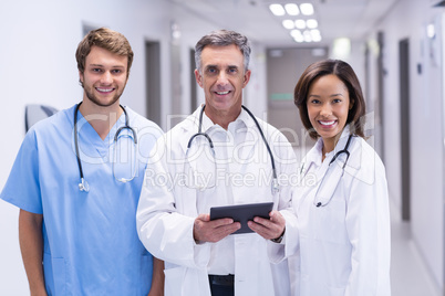 Portrait of doctors using digital tablet in corridor