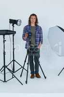 Photographer holding camera in photo studio