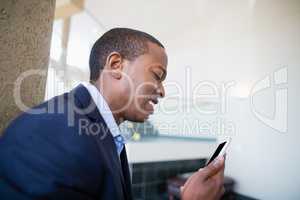 Worried businessman looking at mobile phone