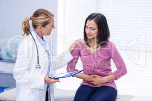 Patient suffering from stomach ache while consulting doctor