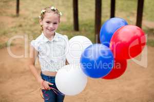 Girl playing with balloons at park