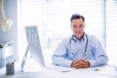 Portrait of male doctor sitting at desk