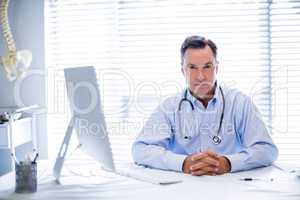 Portrait of male doctor sitting at desk