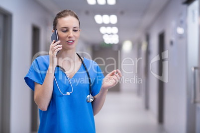 Female doctor talking on mobile phone in corridor