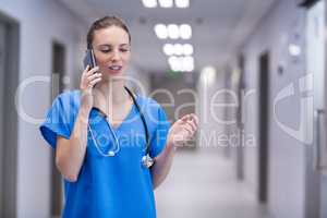 Female doctor talking on mobile phone in corridor