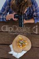 Photographer clicking a picture of food using digital camera