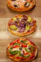 Various delicious italian pizza served on pizza tray at wooden plank