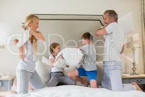 Cute family having a pillow fight in bedroom