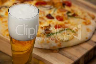 Delicious pizza served on pizza tray with a glass of beer