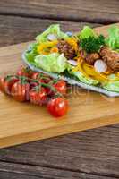 Vegetable salad and cherry tomato on wooden board