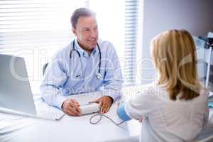 Doctor checking blood pressure of a patient