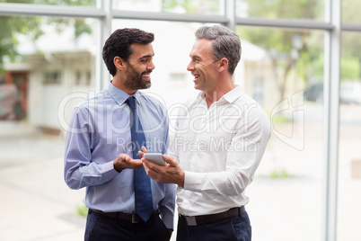 Business executives discussing over mobile phone