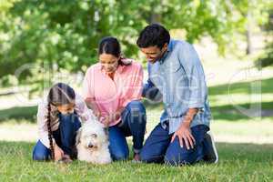 Family enjoying together with their pet dog in park