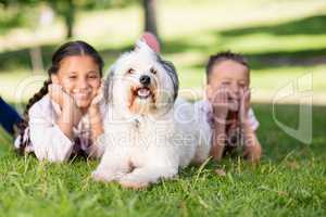Portrait of siblings having fun with their pet dog