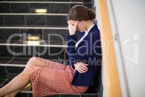 Worried businesswoman sitting on steps