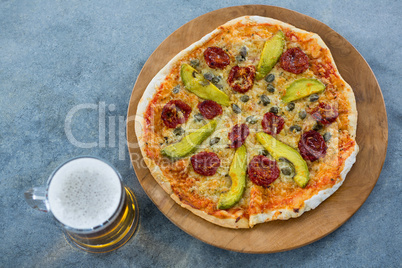 Italian pizza served with a mug of beer