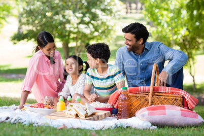 Happy family having breakfast in park