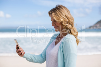 Mature woman taking a selfie from mobile phone on the beach