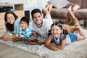 Portrait of parents and children lying on rug and reading book