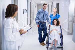 Doctor interacting with pregnant woman in corridor