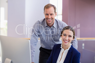 Businesswoman working at desk with colleague