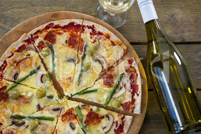 Italian pizza served in a pizza tray with a wine bottle